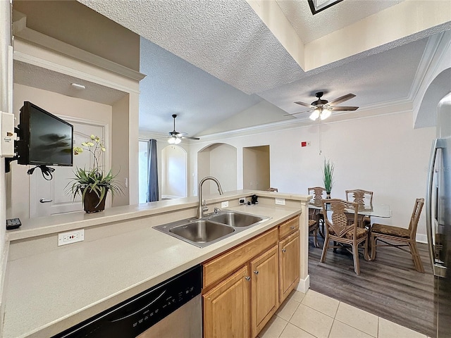 kitchen featuring sink, crown molding, light hardwood / wood-style floors, a textured ceiling, and appliances with stainless steel finishes