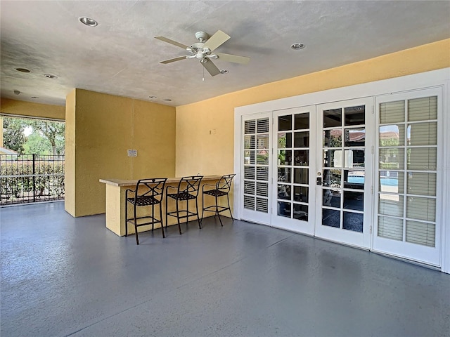 view of patio featuring ceiling fan, french doors, and exterior bar