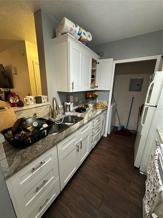 kitchen with white cabinetry, dark hardwood / wood-style floors, sink, and light stone counters