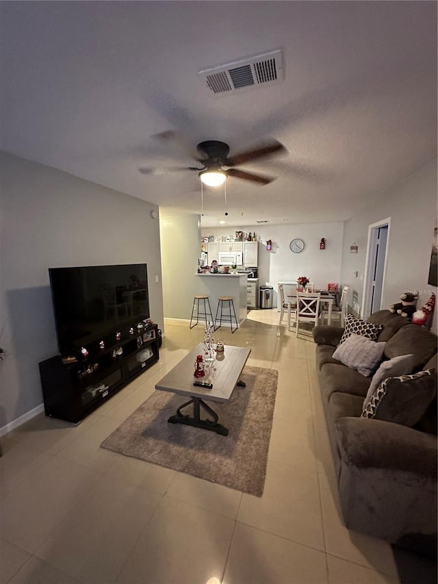 living room featuring ceiling fan and light tile patterned floors