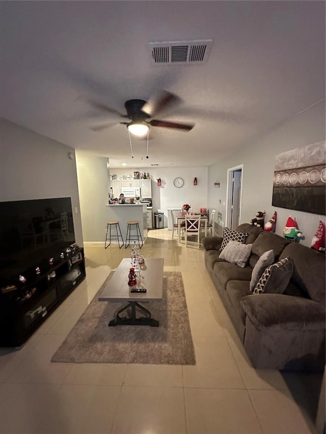 living room with ceiling fan and tile patterned flooring