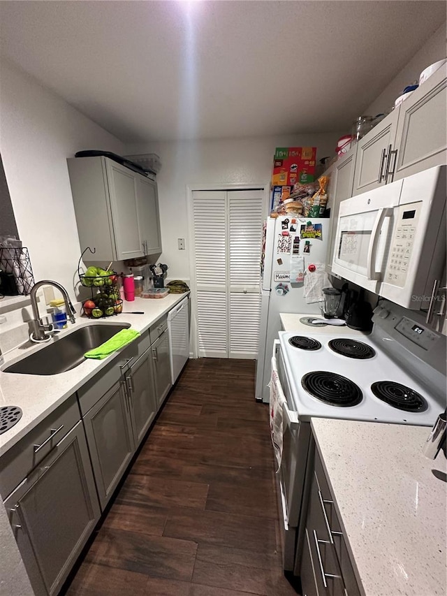 kitchen with white appliances, dark wood-type flooring, gray cabinetry, and sink