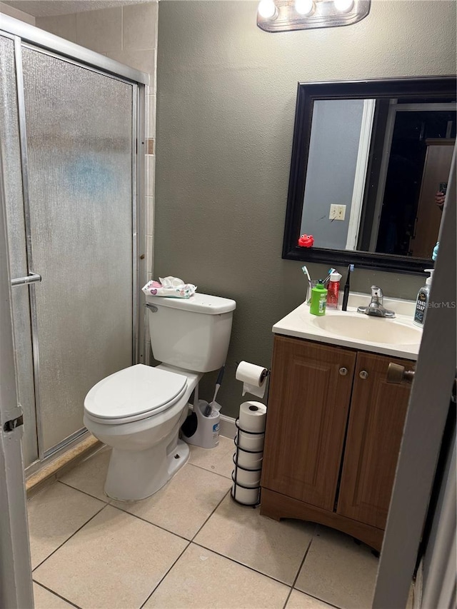 bathroom featuring a stall shower, tile patterned flooring, vanity, and toilet