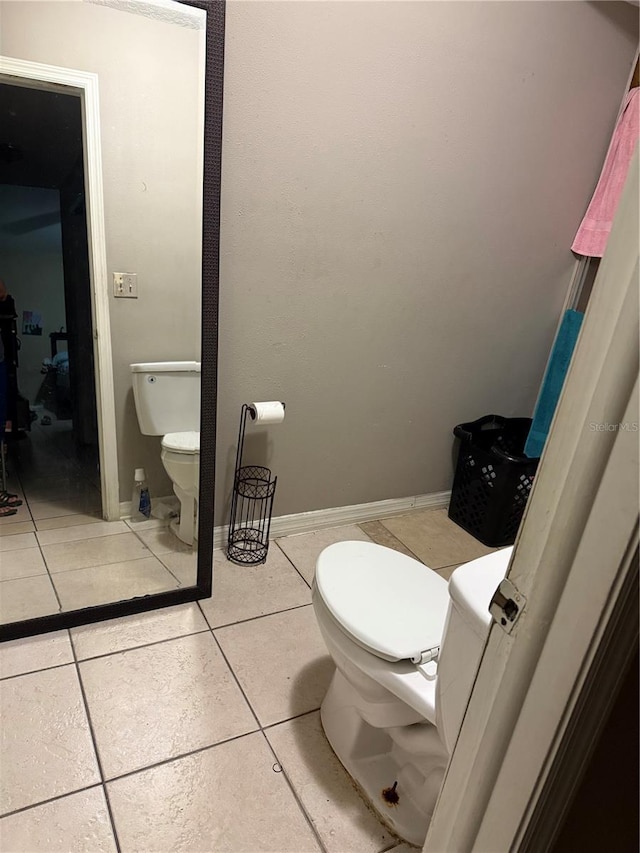 bathroom featuring tile patterned flooring, toilet, and baseboards