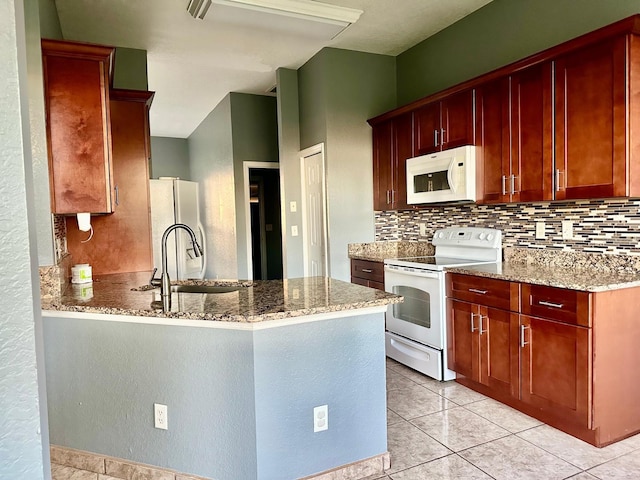 kitchen with light tile patterned flooring, light stone countertops, white appliances, and tasteful backsplash