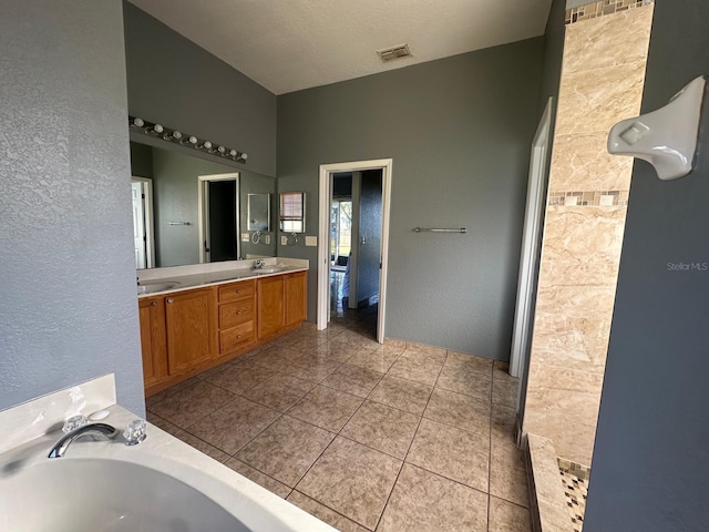 bathroom with tile patterned flooring, vanity, and a tub