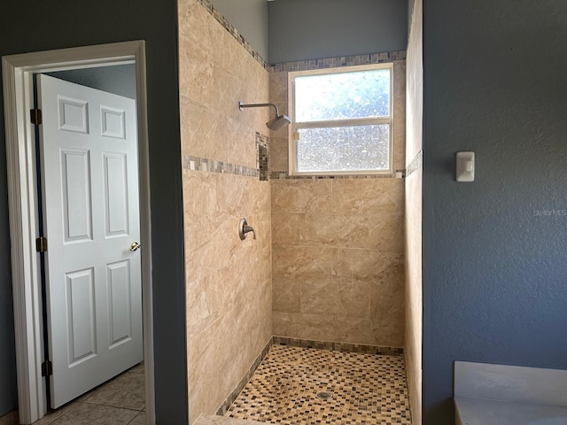 bathroom with tile patterned floors and tiled shower