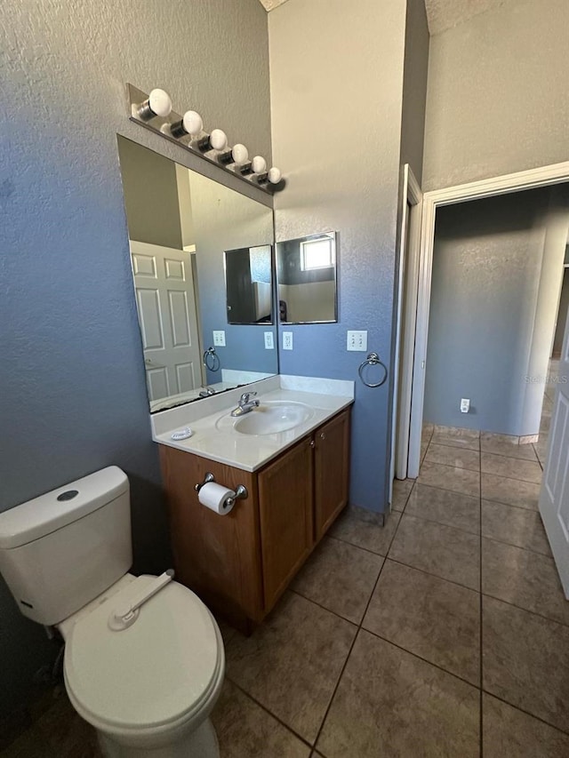 bathroom with tile patterned flooring, vanity, and toilet