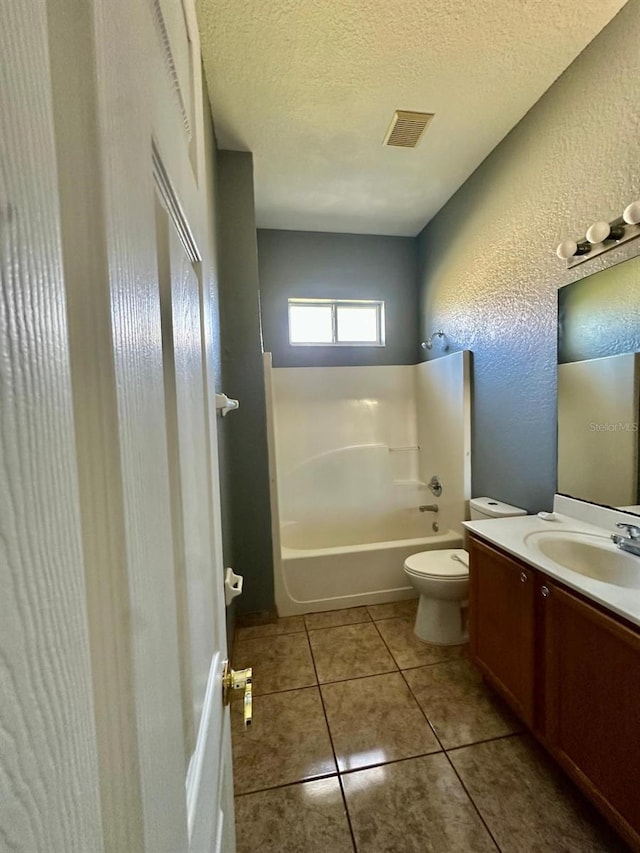 full bathroom featuring tile patterned floors, a textured ceiling, toilet, vanity, and shower / bathtub combination