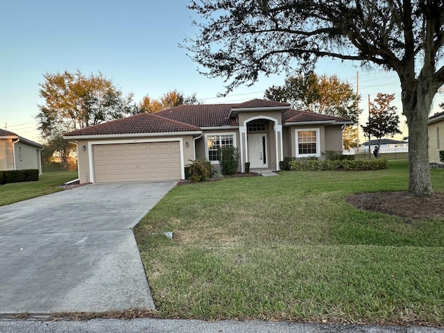 mediterranean / spanish house featuring a yard and a garage