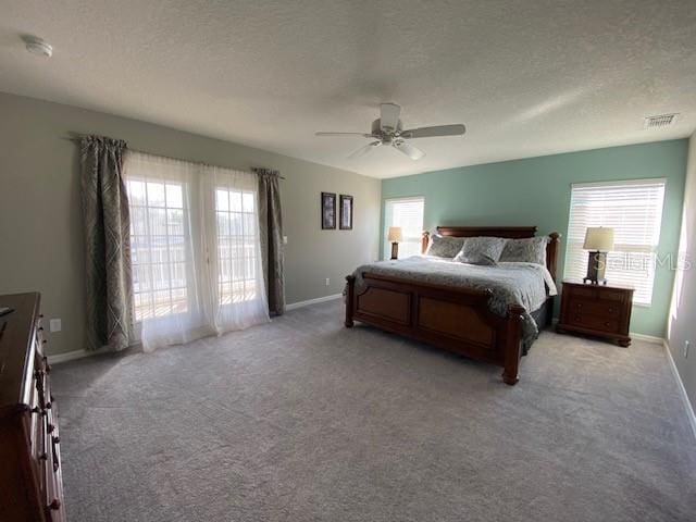 bedroom featuring ceiling fan, light colored carpet, and a textured ceiling