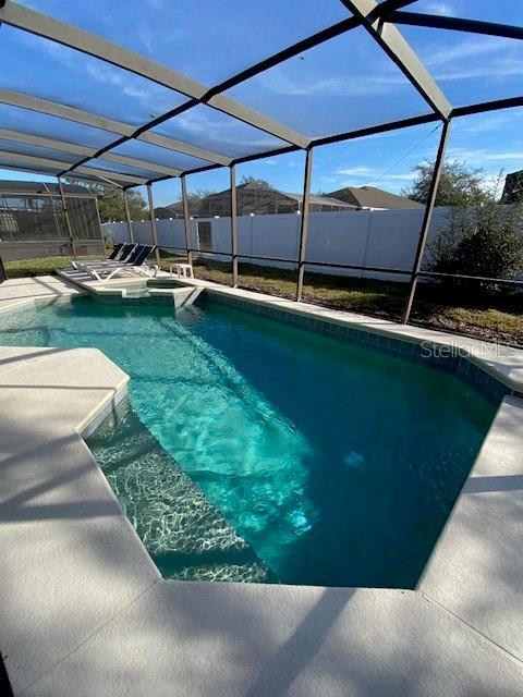 view of swimming pool with a lanai and a patio