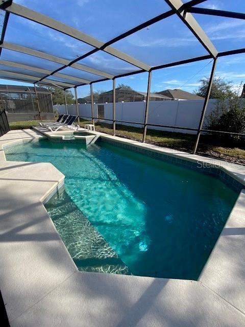 view of swimming pool with a patio area and a lanai