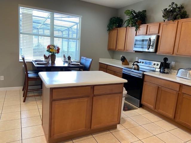 kitchen featuring range with electric cooktop, a center island, and light tile patterned floors