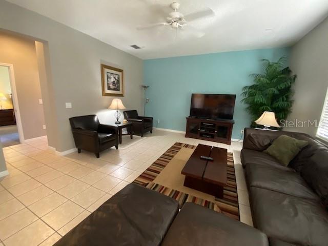 living room with ceiling fan and light tile patterned floors