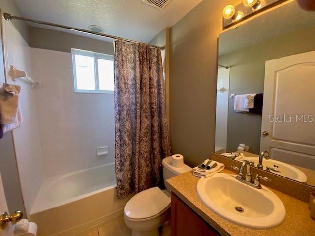 full bathroom featuring tile patterned floors, shower / bath combo with shower curtain, vanity, and toilet