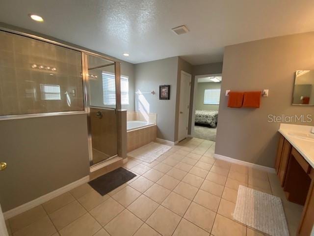 bathroom with a textured ceiling, vanity, tile patterned floors, and independent shower and bath