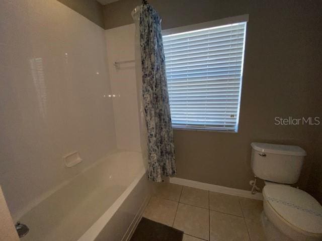 bathroom with tile patterned flooring, toilet, and shower / bathtub combination with curtain