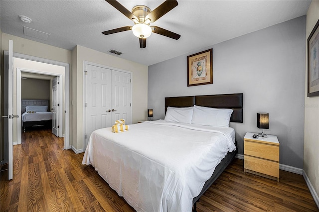 bedroom featuring ceiling fan, a closet, dark wood-type flooring, and a textured ceiling