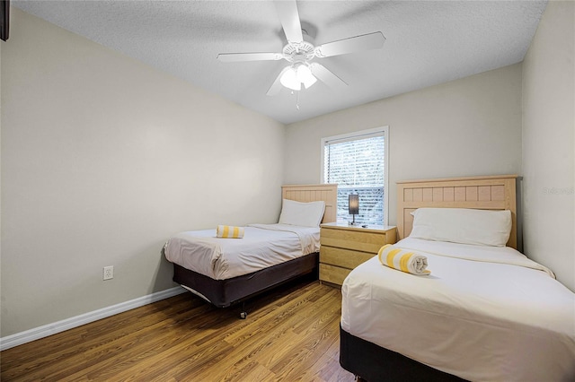 bedroom featuring ceiling fan, wood-type flooring, and a textured ceiling