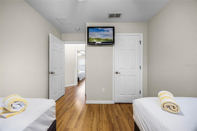 bedroom featuring a textured ceiling and hardwood / wood-style flooring