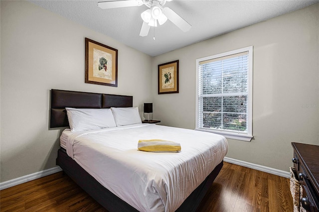 bedroom with ceiling fan, dark hardwood / wood-style flooring, and a textured ceiling