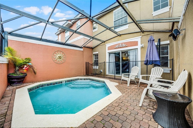 view of pool featuring glass enclosure and a patio