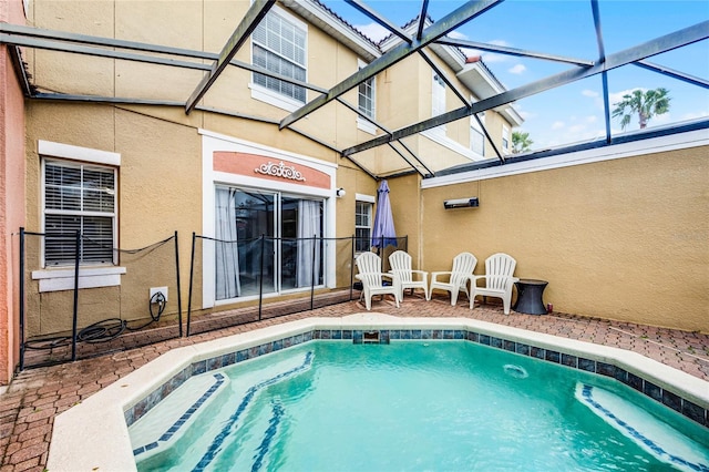 view of pool featuring glass enclosure and a patio