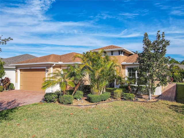 mediterranean / spanish home with a garage and a front lawn