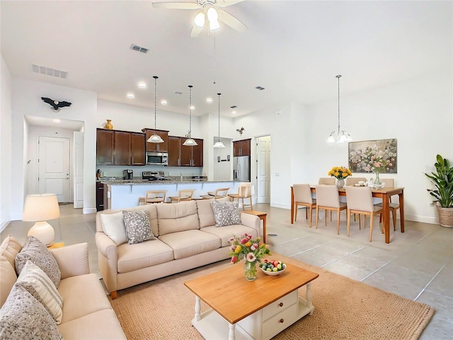 living room with ceiling fan with notable chandelier