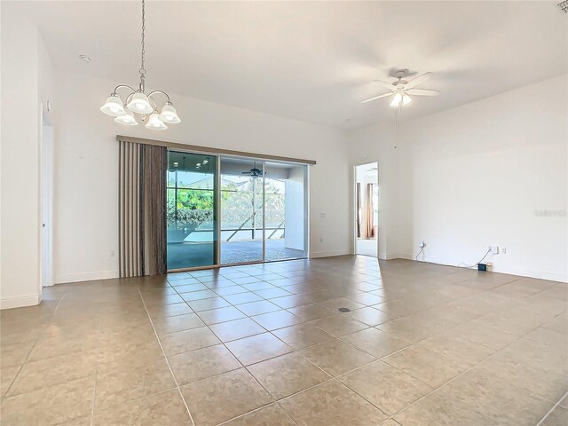 unfurnished room with ceiling fan with notable chandelier and light tile patterned flooring