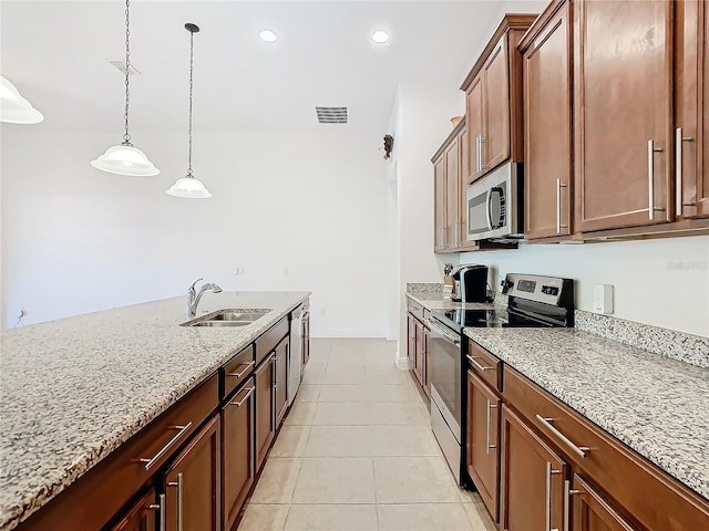 kitchen featuring sink, stainless steel appliances, light stone counters, pendant lighting, and light tile patterned floors