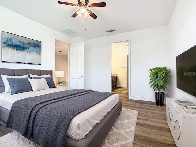 bedroom featuring ensuite bath, ceiling fan, and wood-type flooring