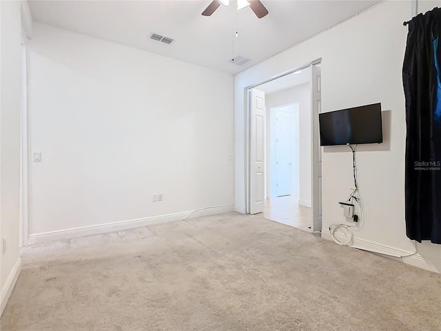 interior space featuring light colored carpet and ceiling fan