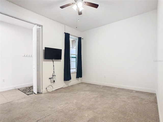 empty room featuring ceiling fan and light carpet