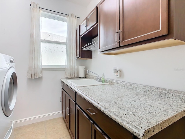 washroom featuring washer / clothes dryer, a wealth of natural light, sink, and cabinets