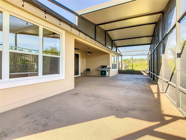 view of patio / terrace featuring glass enclosure, area for grilling, and ceiling fan