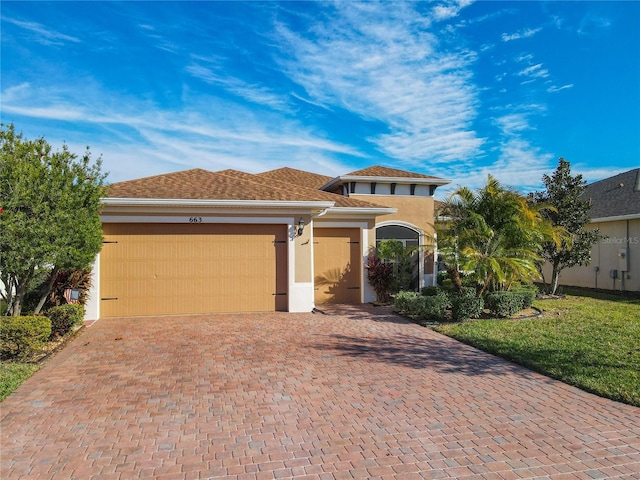 view of front of home with a front yard and a garage