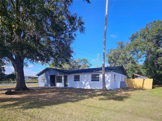 ranch-style home with a front yard and central AC unit