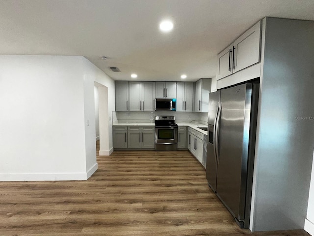 kitchen featuring gray cabinets, dark wood-type flooring, stainless steel appliances, and sink