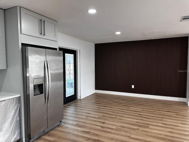 kitchen with stainless steel fridge and light hardwood / wood-style flooring