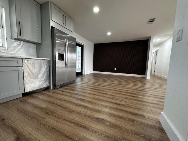 kitchen with stainless steel fridge with ice dispenser, dark hardwood / wood-style floors, and gray cabinetry