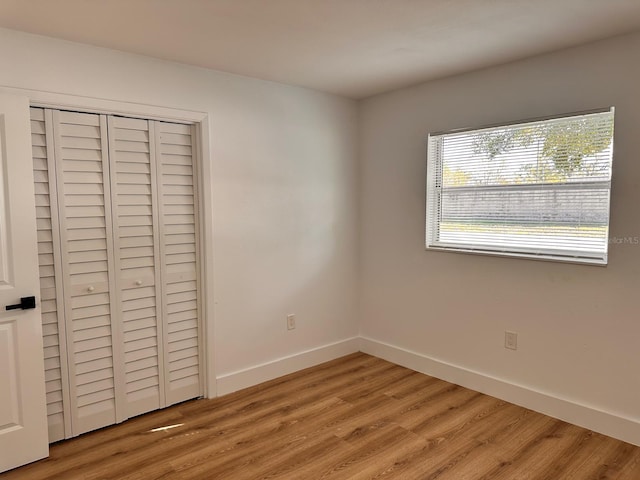 unfurnished bedroom featuring hardwood / wood-style floors and a closet