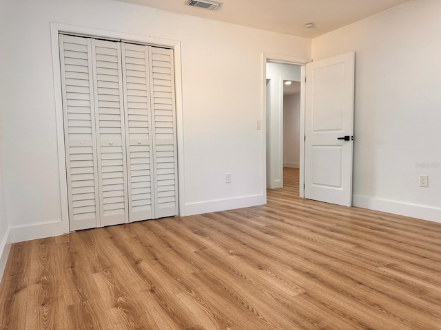 unfurnished bedroom with light hardwood / wood-style floors and a closet