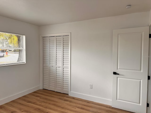 unfurnished bedroom with light hardwood / wood-style floors and a closet