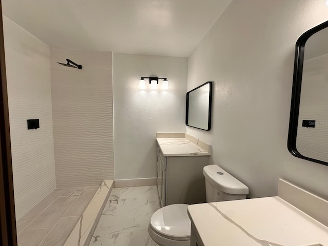 bathroom featuring tiled shower, vanity, and toilet