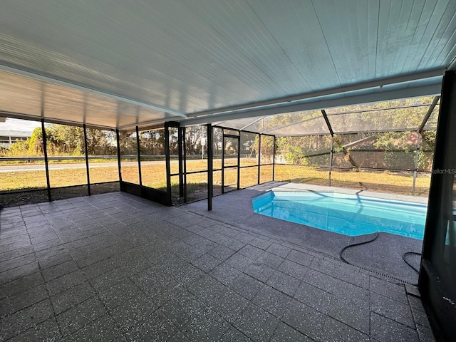 view of swimming pool featuring a patio and glass enclosure