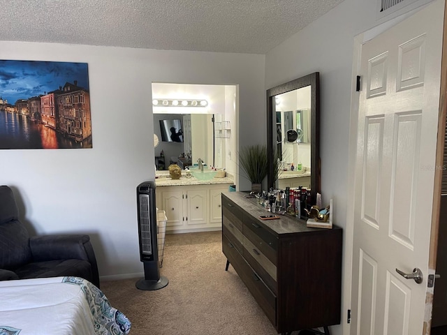 bedroom featuring bar area, a textured ceiling, connected bathroom, and light colored carpet