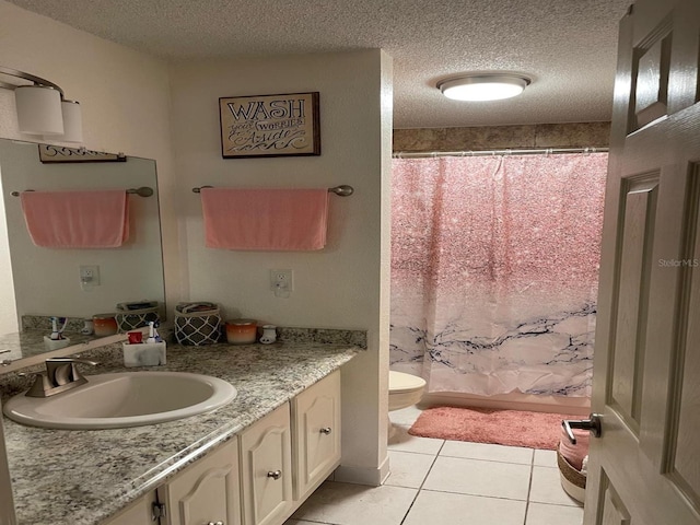 bathroom featuring tile patterned floors, vanity, a textured ceiling, and toilet