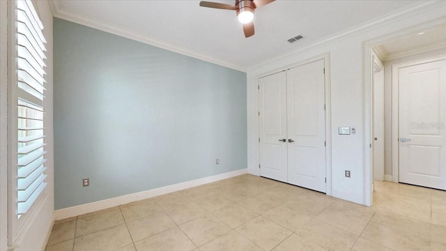 unfurnished bedroom featuring ceiling fan, crown molding, and a closet